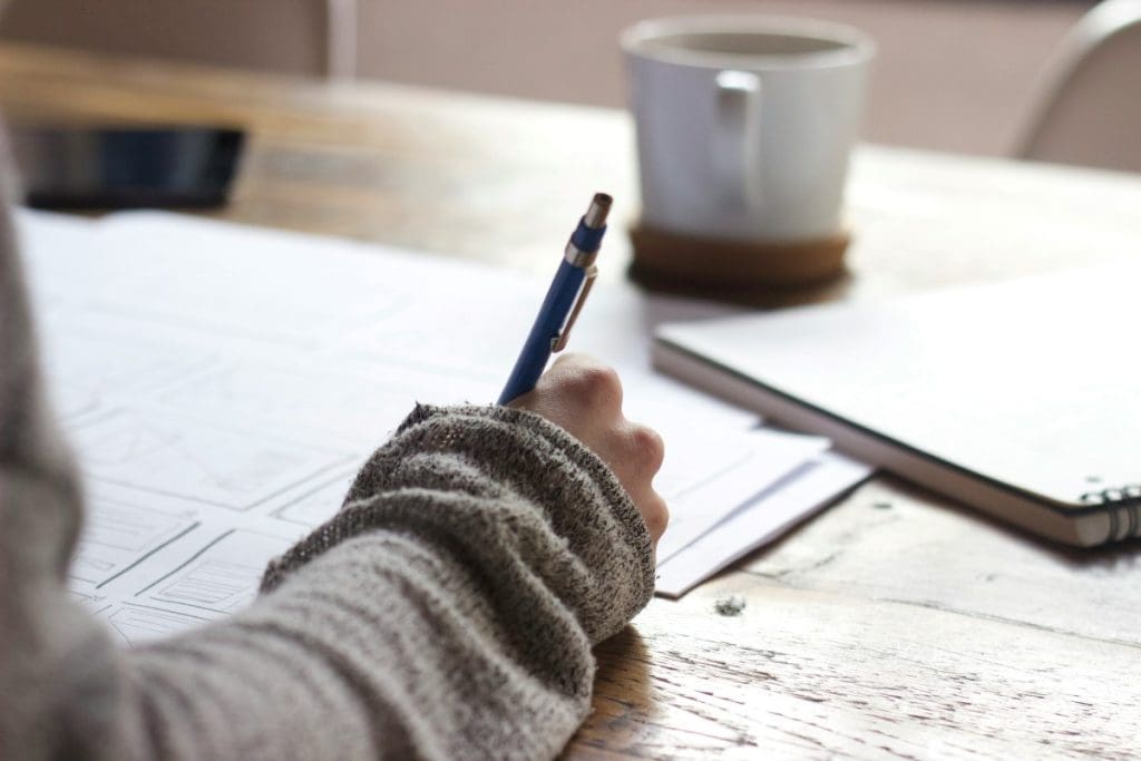 A person writing at a table