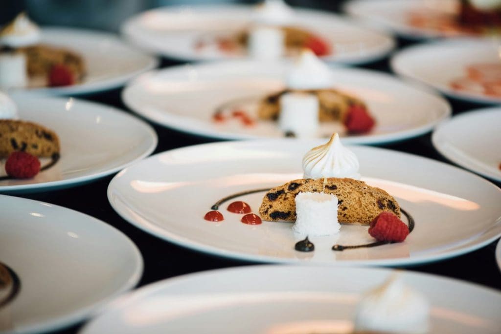 Multiple white plates with desserts on them