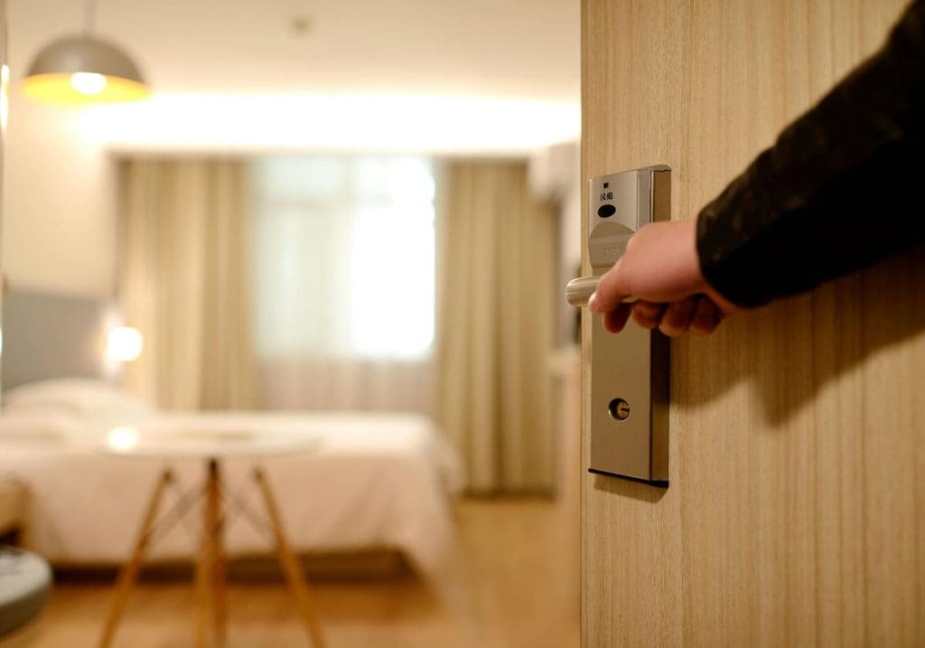 A person opening the door to a hotel room