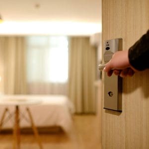 A person opening the door to a hotel room