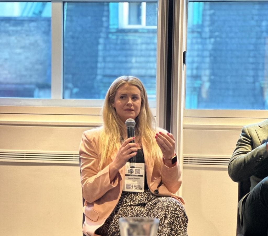 A woman talking into a microphone and gesturing during a panel discussion at the Association of Serviced Apartment Providers Annual Conference 2024